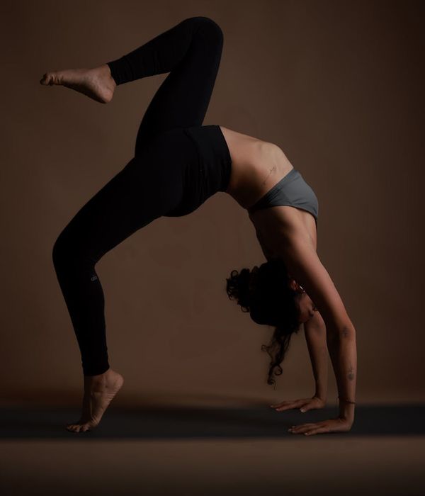 Woman practicing mindful yoga in a dark aesthetic studio